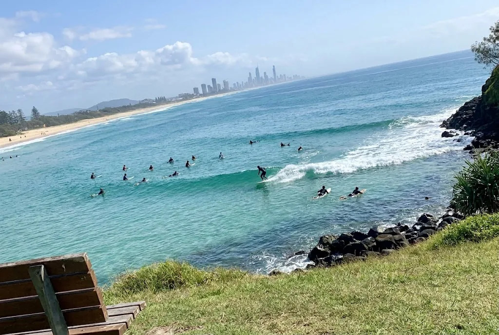 Surfers riding long peeling right-hand point break wave at Burleigh Heads Gold Coast