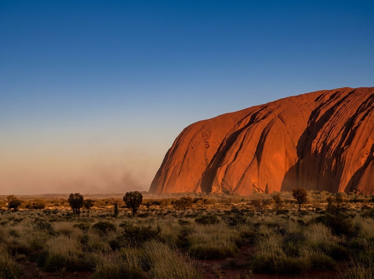 How to plan a trip to Australia: Uluru glowing ochre-red at golden hour in the Red Centre desert